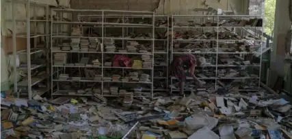  ?? Leo Correa/Associated Press ?? Librarian Raisa Krupchenko, 81, tries to organize books at the library of the destroyed School Number 23 in Kramatorsk, Ukraine, in August 2022 after a Russian attack.