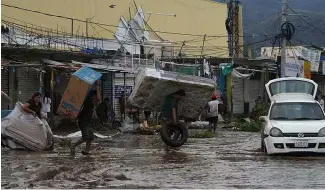  ?? ?? People carry away a mattress, a television monitor and a bicycle from a store at a shopping mall after Hurricane Otis ripped through Acapulco, Mexico, Oct. 25, 2023