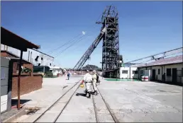  ??  ?? Mine workers walk past the pit head at Sibanye Gold’s Masimthemb­e shaft in Westonaria. The mining giant’s negotiatio­ns were hit hard by the promulgati­on of the hew mining charter.