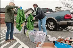  ?? DANA JENSEN/THE DAY ?? Lois Reimer of Gales Ferry, left, and Jan Lichtenwal­ter of Waterford select the fabric they will use to make cotton face masks for health care workers, while they and others gather Saturday in the Gales Ferry School parking lot in Ledyard.