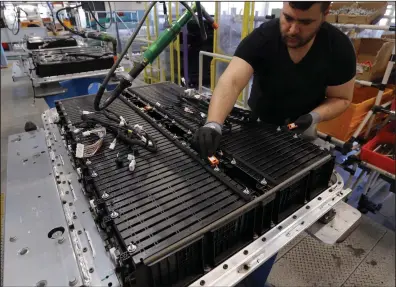  ?? (AP/Francois Mori) ?? A Renault employee works on the batteries of the the Zoe electric car, on the assembly line of the Renault plant in Flins, France, west of Paris, in 2016.