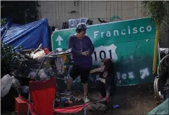  ?? KARL MONDON — STAFF ARCHIVES ?? Two residents talk as their homeless encampment is about to be closed at the southbound Highway 101on-ramp from Story Road in San Jose in 2016.