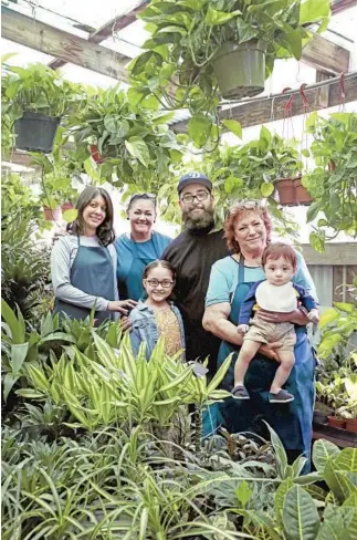  ??  ?? MARIA LUZ LOPEZ, above, with grandson Ernesto Jr. and family in the “green room” at Avalon Nursery & Ceramics in South Los Angeles; Cenaido Hernandez, left, in “the jungle”; and a customer, below, shops near Our Lady of Guadalupe statues.