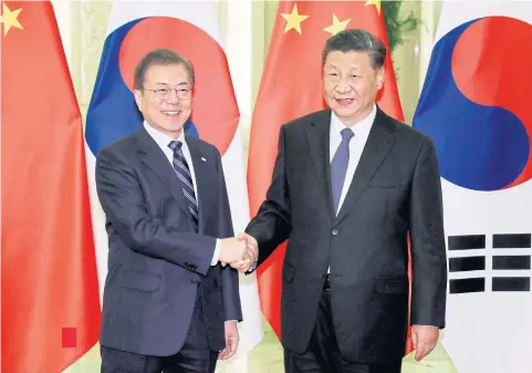  ?? AFP ?? South Korea’s President Moon Jae-in, left, shakes hands with China’s President Xi Jinping at the Great Hall of the People in Beijing yesterday.