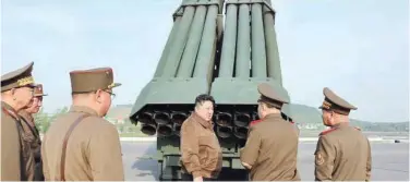  ?? Associated Press ?? ↑ Kim Jong Un (centre) supervises a test firing of a new multiple rocket launch system at an undisclose­d place in North Korea on Saturday.