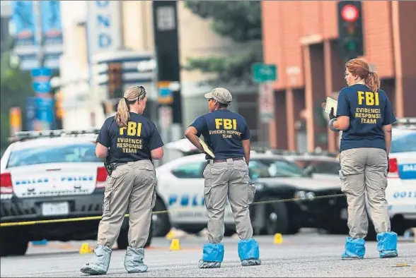  ?? SPENCER PLATT / AFP ?? Miembros de un equipo de búsqueda de pruebas del FBI, ayer en el lugar del tiroteo en el centro de Dallas
