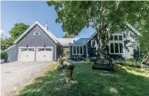  ??  ?? This two-storey detached home features a board-and-batten exterior, covered porch, flagstone walkway, garden beds and lawn.