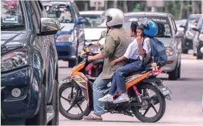  ?? ADIB RAWI YAHYA/THESUN ?? ... This motorcycli­st does not seem to care that he is putting these young children at risk as he zig-zags through traffic along Jalan Cheras, Kuala Lumpur, yesterday. To make it worse, the boy in the centre is not wearing a safety helmet while the...