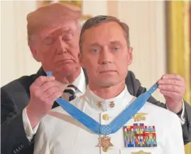  ?? SUSAN WALSH/ AP ?? President Donald Trump awards the Medal of Honor to Master Chief Special Warfare Operator Britt K. Slabinski at the White House on Thursday.