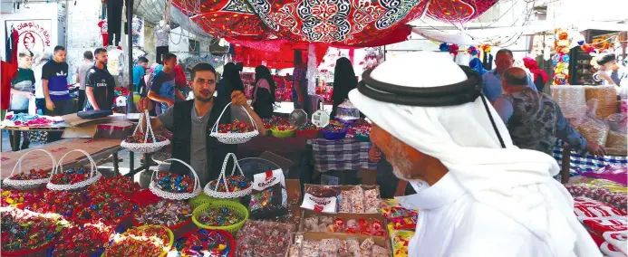  ??  ?? PERUSING GOODS on offer in Gaza’s shuk.