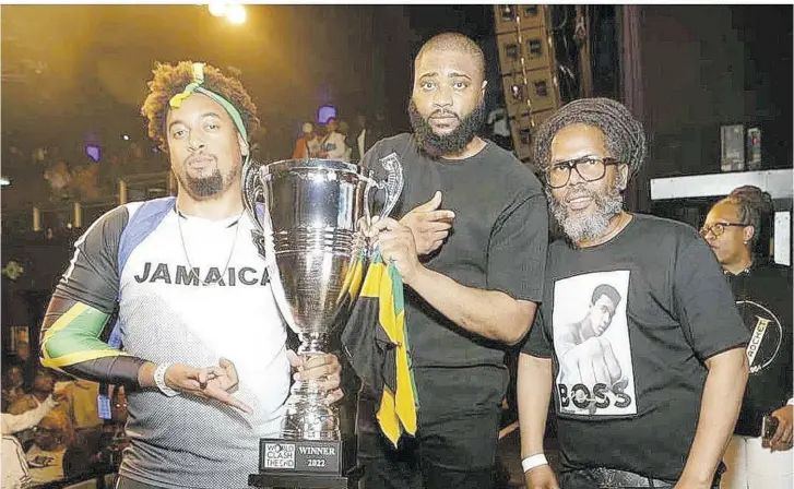  ?? ?? From left: Selectors DJ Lank and Chris Dymond of Code Red pose with the coveted World Clash trophy, while Garfield “Chin” Bourne of promoters Irish and Chin looks on. Occasion was World Clash: The End, at the O2 Academy in Birmingham, England, on Sunday.