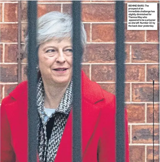  ??  ?? BEHIND BARS: The prospect of an immediate challenge has slightly diminished for Theresa May who appeared to be a prisoner as she left Number 10 by the back door yesterday