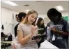  ?? ANNIE MAYNE/MARIETTA DAILY JOURNAL ?? Dickerson Middle School students Rori Smith and Aria Tettey, members of the Pay It Forward Club, pack bags of toiletries for families staying in Ronald McDonald Houses.