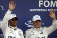  ?? DARKO BANDIC — THE ASSOCIATED PRESS ?? Mercedes driver Lewis Hamilton of Britain, left, celebrates his pole position with second placed Mercedes driver Valtteri Bottas of Finland, following the qualificat­ion at the Formula One Azerbaijan Grand Prix in Baku, Azerbaijan, Saturday, June 24,...