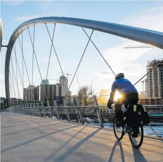  ?? LYLE ASPINALL ?? A cyclist cruises over the St. Patrick’s Bridge in the East Village, which saw one of the city’s most successful community engagement programs, writes Richard White.