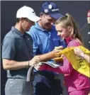  ?? DAVE THOMPSON, THE ASSOCIATED PRESS ?? Ireland’s Rory McIlroy, left, and Padraig Harrington sign autographs for fans during the second practice day at the British Open golf tournament in the city of Southport, England.