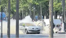  ?? NOEMIE PFISTER VIA AP ?? Gendarmes use fire extinguish­ers after a man rammed into a police convoy and detonated an explosive device in Paris on Monday.