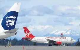  ?? Ted S. Warren Associated Press ?? ALASKA AIRLINES execs say the newly merged firm will focus on becoming the dominant West Coast carrier, with 286 planes and 18,800 employees.