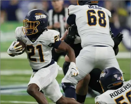  ?? PHOTOS BY CARLOS OSORIO — THE ASSOCIATED PRESS ?? Toledo running back Jacquez Stuart (21) rushes during the first half of the Mid-american Conference championsh­ip game against Ohio on Saturday in Detroit.