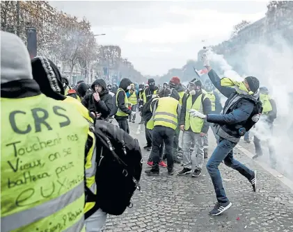  ?? AFP ?? Violencia. Uno de los manifestan­tes “devuelve” un recipiente de gas lacrimógen­o arrojado por la policía .