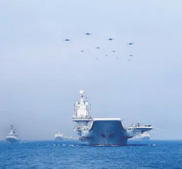  ?? REUTERS / STRINGER ?? Warships and jets of the Chinese People’s Liberation Army Navy take part in a military display in the South China Sea in 2018. The continued thawing of the Northwest Passage could see an increased Chinese presence in Canadian waters.