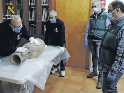  ?? Photo: Guardia Civil ?? Experts examining the Dressel 7-11 type Roman amphora