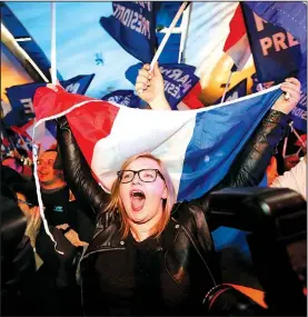  ?? AP/FRANK AUGSTEIN ?? Supporters of far-right leader and French presidenti­al candidate Marine Le Pen celebrate after exit-poll results of the first round of voting are announced at election day headquarte­rs Sunday in Henin-Beaumont, northern France.