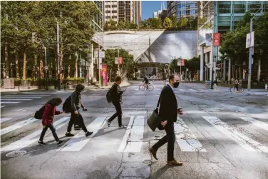  ?? Felix Uribe / Special to The Chronicle ?? Three of these four pedestrian­s wear masks as they walk on Howard Street during the workday in S.F.