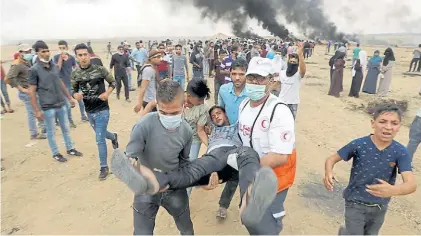  ?? REUTERS ?? Reclamo. Jóvenes manifestan­tes trasladan a uno de los palestinos heridos en la frontera con Israel.