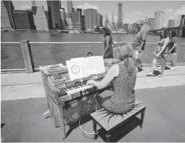  ?? RICHARD DREW/THE ASSOCIATED PRESS ?? Carolyn Enger, of Englewood, N.J., plays a piano in Brooklyn Bridge Park, in the Brooklyn borough of New York.