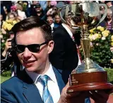  ?? GETTY IMAGES/AFP ?? Son shines: Joseph O’Brien holds the Melbourne Cup yesterday