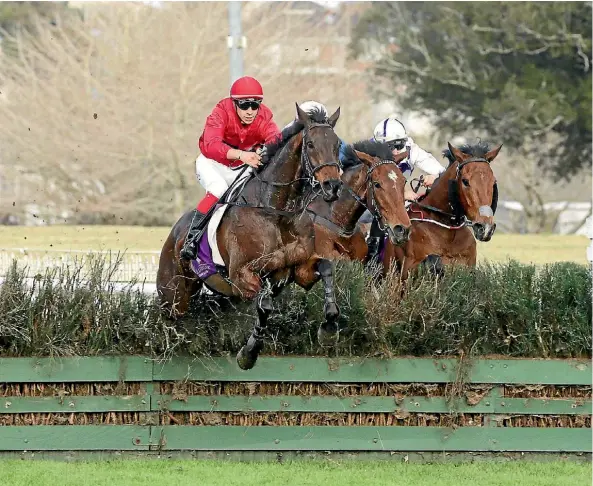  ??  ?? Jockey Aaron Kuru coaxes Amanood Lad over an obstacle on their way to victory in the Pakuranga Hunt Cup at Ellerslie.