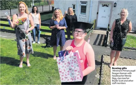  ??  ?? Bearing gifts Minishant Primary pupil Reagan Keenan with headteache­r Wendy Rigg, class teacher Brydie Scott and other staff members