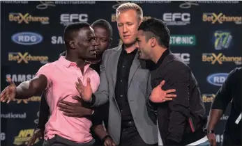  ??  ?? CALM DOWN GUYS: Demarte Pena, left, and Irshaad Sayed are kept apart ahead of their EFC bantamweig­ht grudge match in Pretoria tonight Picture: EFC Worldwide