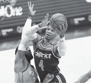  ?? Nick Wass / Associated Press ?? Wizards guard Russell Westbrook drives on the Rockets’ David Nwaba while doing a bit of everything Monday night to finish with 16 points, 13 rebounds and 15 assists.