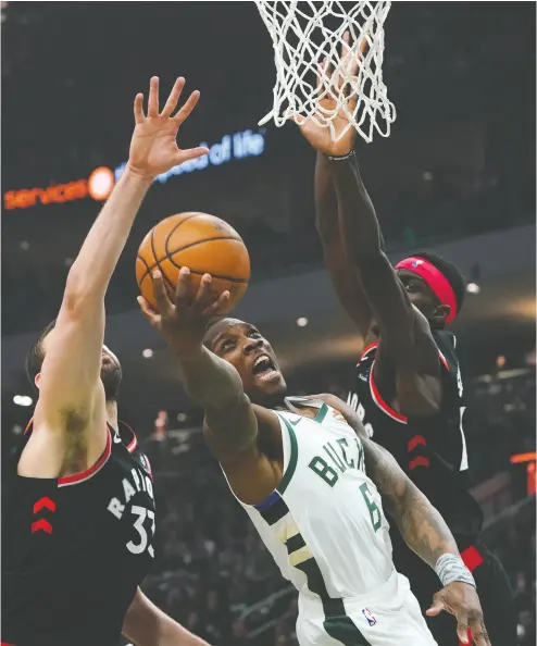  ?? Mory Gash / the asociated pres ?? Milwaukee’s Eric Bledsoe shoots between Raptors Marc Gasol and Pascal Siakam in Friday night’s game.