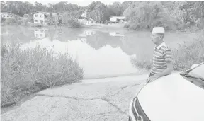  ??  ?? RINDU: Kassim merenung perkampung­an di Temburong, Brunei di sempadan Jalan Pandaruan, Limbang kelmarin.