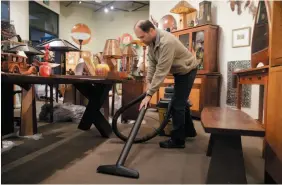  ?? AP FILE PHOTO ?? Steve Kirkish uses a shop vacuum to clean the carpets in his shop after a storm on Dec. 11, 2014 in Healdsburg, Calif. If your carpets are constantly dirty along the walls of a room, soil filtration could be to blame.