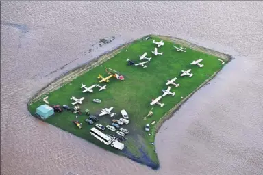  ?? DAVE HUNT / REUTERS ?? Floodwater­s surround aircraft near the town of Lismore, New South Wales, Australia, on Friday, after Cyclone Debbie swelled rivers to record heights across the region.