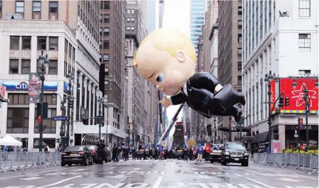  ?? Reuters ?? ↑
Assistants carry ‘The Boss Baby’ balloon during the 94th Macy’s Thanksgivi­ng Day Parade closed to spectators due to the coronaviru­s in New York on Thursday.
