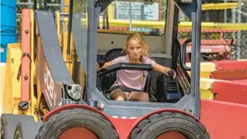 ?? TONY CENICOLA/THE NEW YORK TIMES PHOTOS ?? A young visitor at the controls of a skid steer truck navigates a course Aug. 8 at the constructi­on-themed amusement park.