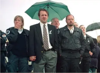  ?? GETTY IMAGES ?? Emergency physician Dr. Chris Colwell, shown wearing a tie, listens during a memorial service as the names are read of the victims who died in the 1999 Columbine High School shooting. Colwell tended to the wounded and dying at the scene.