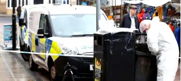  ??  ?? A police officer searches an area in the town centre after reports of a stabbing in Barnsley. — Reuters photo