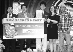  ??  ?? Ha How Ung (third right) receives the Best Student Award with a cash prize of RM2,000 from Hii, while Teo (left) and others look on.