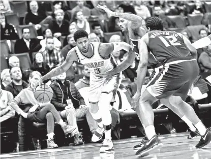  ?? AP ?? OUT OF MY WAY. Oklahoma City Thunder forward Paul George (13) tries to push past Phoenix Suns forward Trevor Ariza (3) and T.J. Warren (12) in the second half of an NBA basketball game in Oklahoma City, Monday, Nov. 12, 2018.