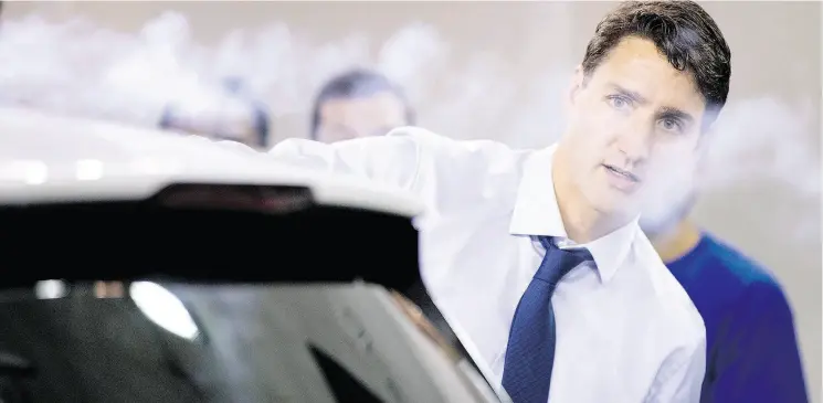  ?? CHRIS YOUNG / THE CANADIAN PRESS ?? Prime Minister Justin Trudeau uses a smoke wand at a demonstrat­ion of air flow over a car during a visit to the University of Ontario’s Institute of Technology in Oshawa Friday.