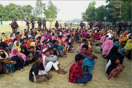  ?? — AFP ?? Shunned and stateless: Bangladesh­i soldiers standing guard over a large group of Rohingya caught while crossing the Naf river from Myanmar in this file picture.