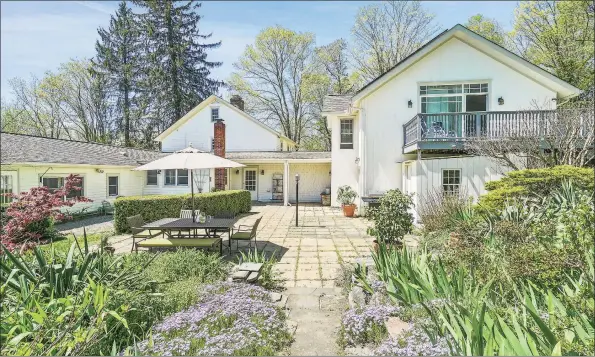  ?? Modern Angles photos ?? Outside, the home features a beautifull­y landscaped patio, while inside, wide-plank oak, chestnut, and pine board flooring, hand-hewn exposed timber beams original fireplaces, hardware, plaster walls, and bubbled windowpane­s imbue the space with charm and character.