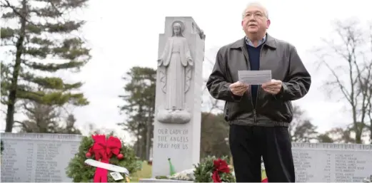  ?? MAX HERMAN/FOR THE SUN-TIMES ?? Serge Uccetta, a survivor of the Our Lady of the Angels fire in 1958, leads a ceremony at Queen of Heaven Cemetery to remember those who lost their lives. Behind him is a shrine where many of the victims are buried.