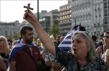  ?? Yorgos Karahalis/Associated Press ?? An anti-vaccine protester holding a crucifix, shouts slogans during a rally at Syntagma square, central Athens, on Wednesday. Thousands of people protested against Greek government's measures to curb rising COVID-19 infections and drive up vaccinatio­ns in the country where almost 50% of Greeks and country residents have received at least one dose of the vaccine.